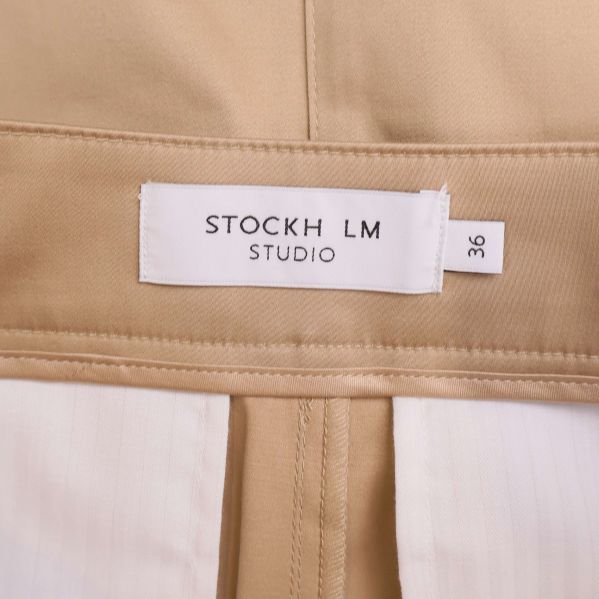 Vit tyglabel med STOCKH LM STUDIO och storlek 36