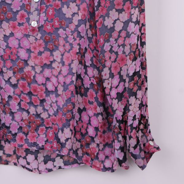 Närbild på ärmslut och tyg med blommigt mönster i rosa toner