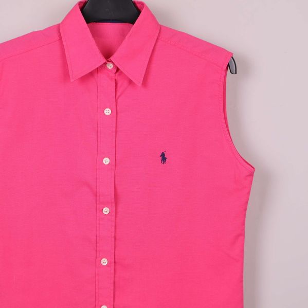 Närbild på broderad logotyp på rosa skjorta