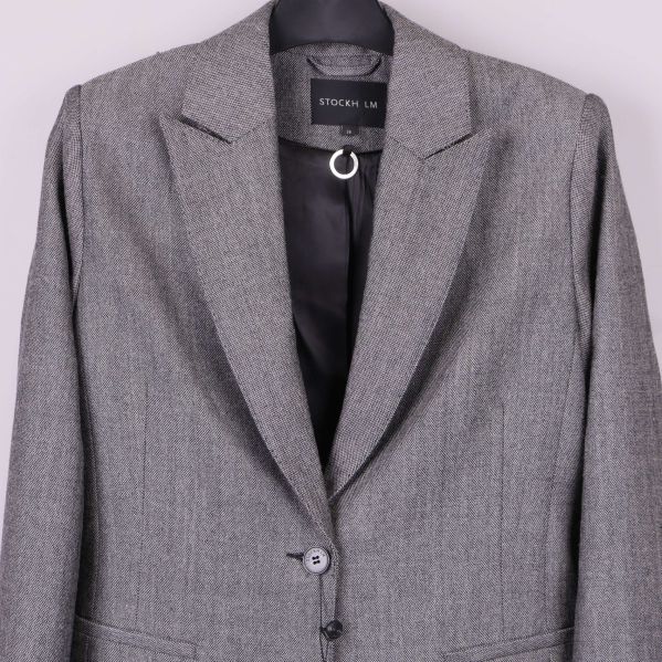 Närbild på blazer med etiketten STOCKH LM synlig i nacken