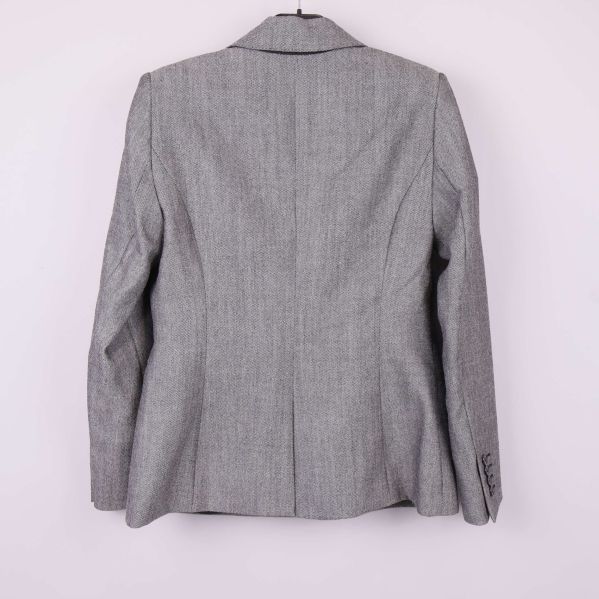 Baksidan av grå blazer med tydliga sömmar och kavajkrage