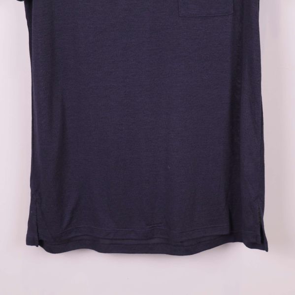 Nedre del av blå t-shirt, visar fåll och materialstruktur