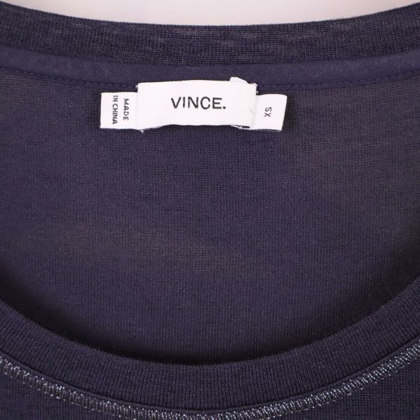 Närbild etikett med märket Vince. i halsen på t-shirten