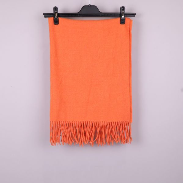 Orange sjal vikt med fransar nedtill på galge
