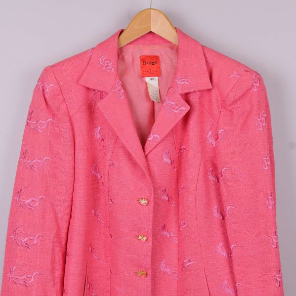 Närbild på överdel och krage av rosa broderad kavaj