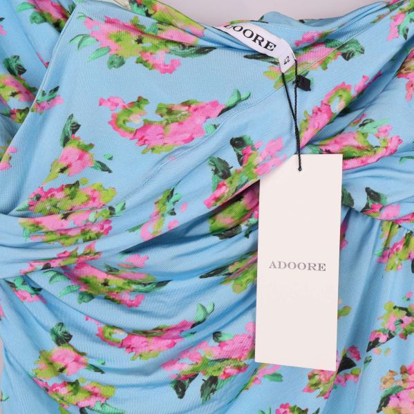 Närbild på blommigt tyg med Adoore-hangtag