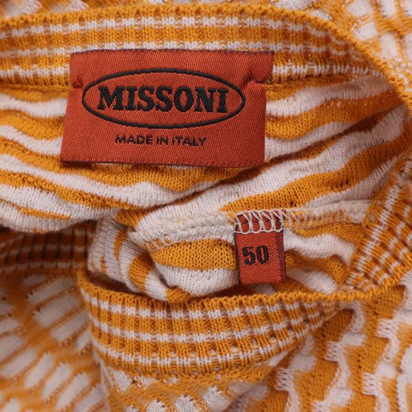 Närbild på Missoni-logotyp och storleksetikett i tröjan