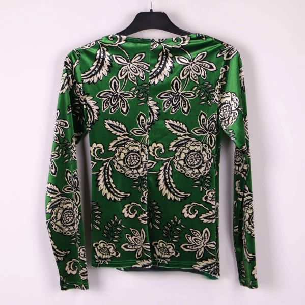 Baksidan av grön blus med blommigt mönster och lång ärm