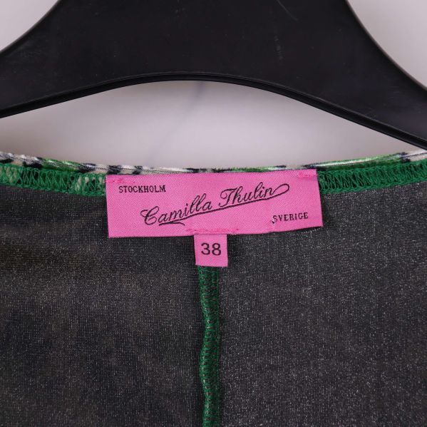 Närbild på rosa etikett märkt Camilla Thulin och storlek 38