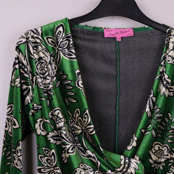 Närbild på urringningen och draperingen på blusens framsida