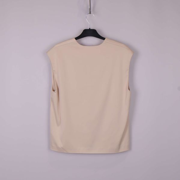 Baksidan av ärmlös beige topp på galge