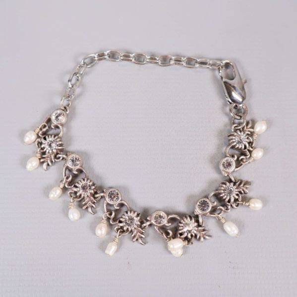 Armband med hängande vita pärlor och blommotiv i silverfärg