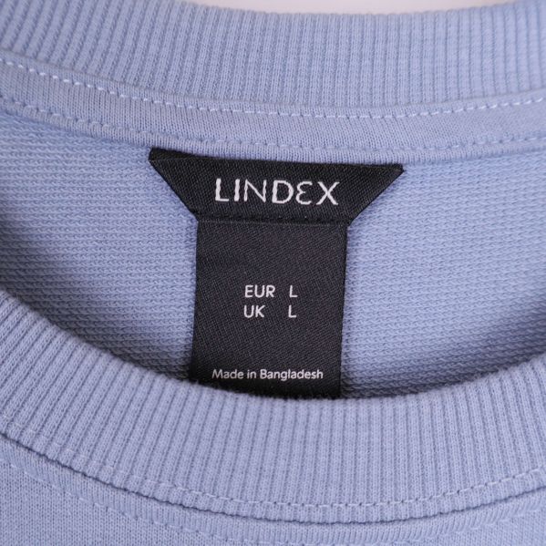 Närbild på Lindex-lappen och ribbad krage på sweatshirt