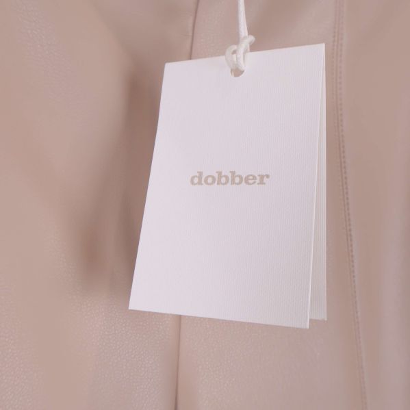 Närbild på vit hangtag med dobber-logotyp på byxorna