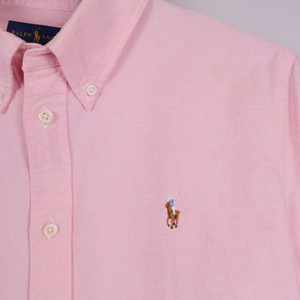 Närbild på bröstlogo och krage på rosa skjorta