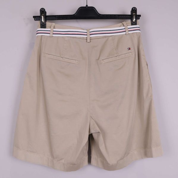 Baksida av beige shorts med fickor och logotyp