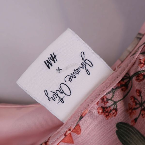 Närbild på märkesskylt Johanna Ortiz x H&M i klänningen