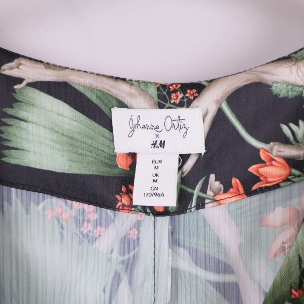 Närbild på etikett med storlek och samarbete H&M x Johanna Ortiz