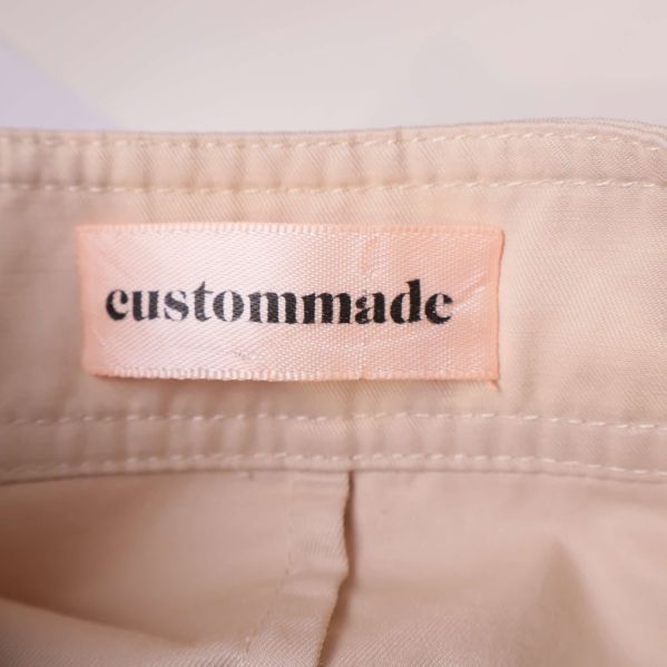 Närbild på custommade-märke i ljusrosa på insidan av klänningen