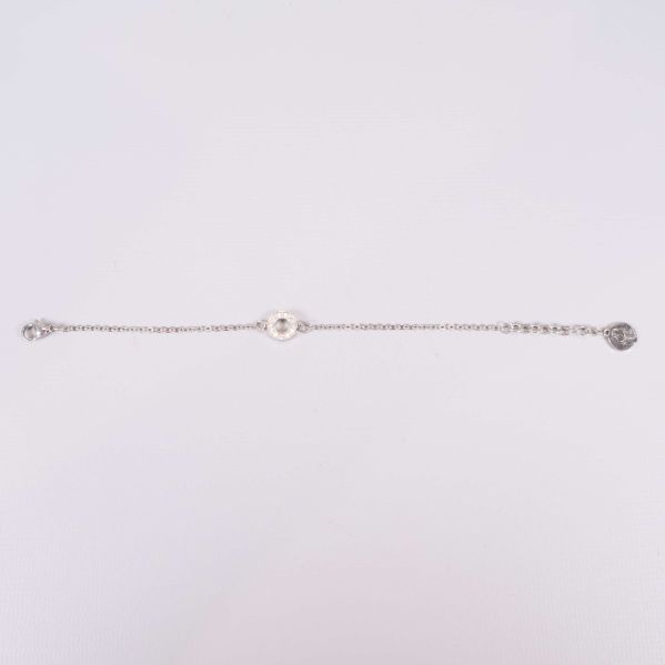 Helt utsträckt silverfärgat armband på ljus bakgrund