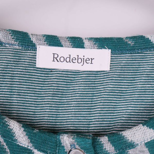 Närbild på etikett med Rodebjer-logotyp i halsen
