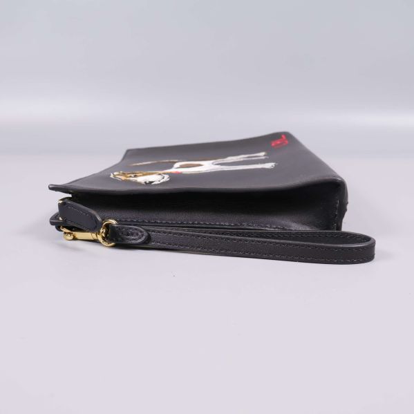 Svart clutch i profil med guld dragkedja och rem