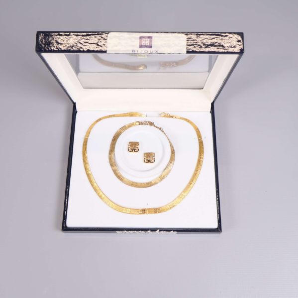 Öppet smyckeset med halsband och örhängen placerade i vit ask