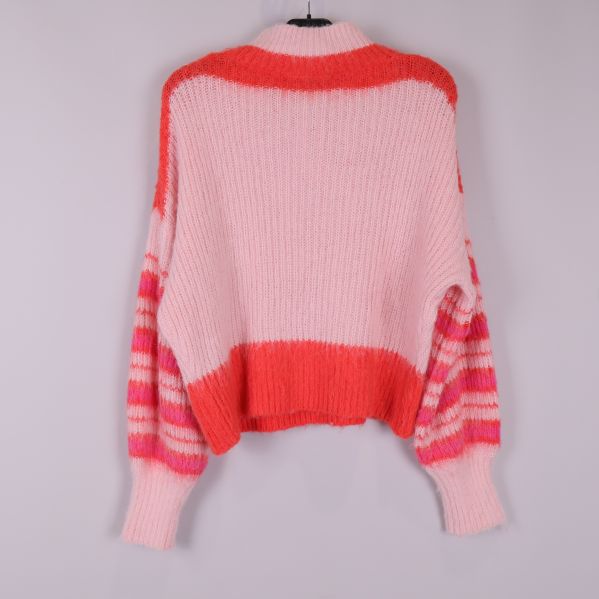 Baksidan på stickad tröja med röd och rosa färgblock