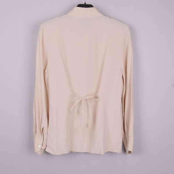 Beige blus sedd bakifrån med knytband