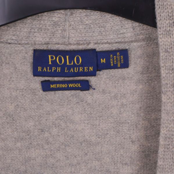 Närbild av POLO Ralph Lauren etikett samt merinoull-lapp