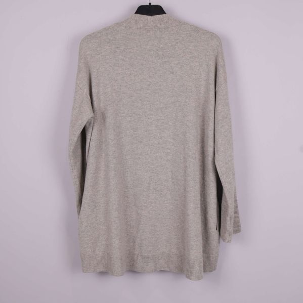 Baksidan av beige lång kofta upphängd på galge