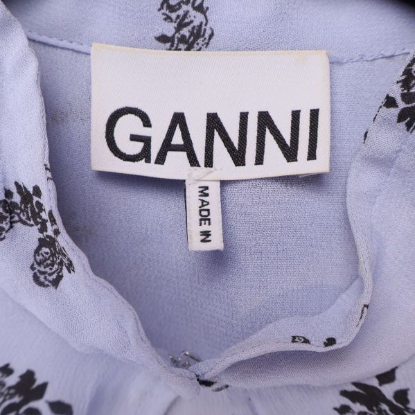 Närbild på Ganni-märke i ljusblå klänning