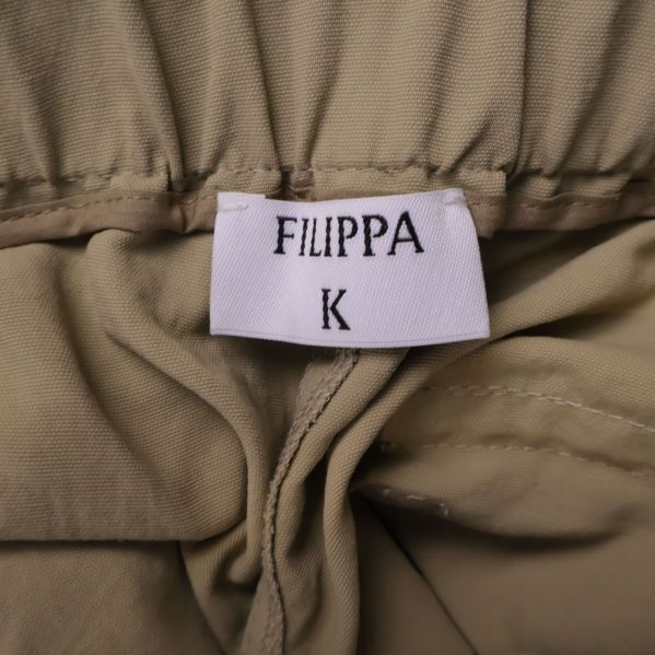 Närbild på Filippa K-logotyp i midjan