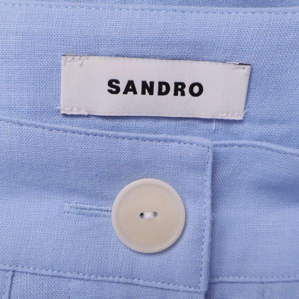 Närbild på Sandro-etikett och vit knapp i kjolen