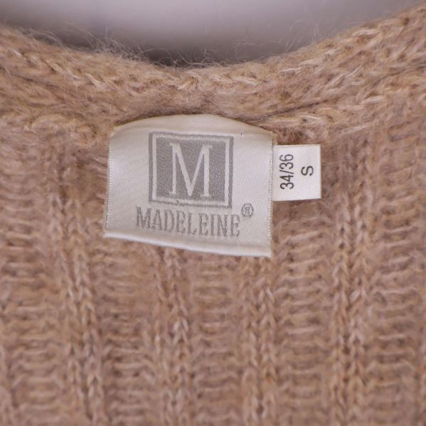 Närbild på Madeleine-märkesetikett och storlekslapp 34/36 S