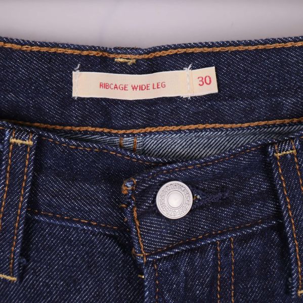 Etikett med texten Ribcage Wide Leg och storlek 30