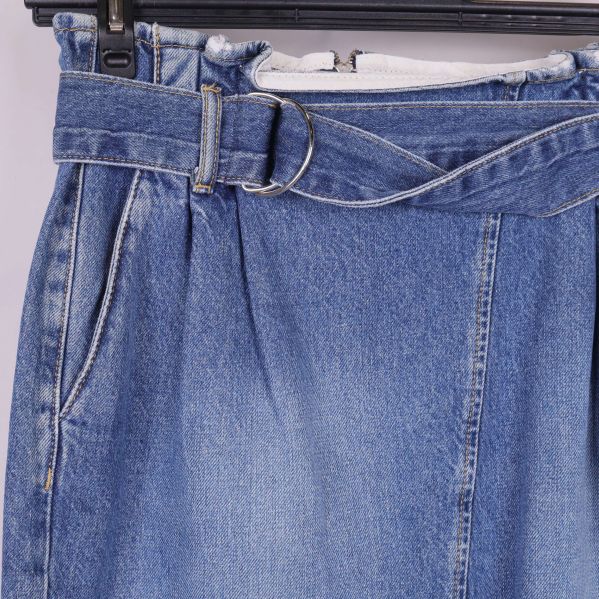 Närbild på midjebälte och metallspänne på jeanskjol