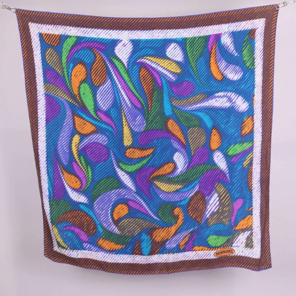 Stor fyrkantig scarf med grafiskt färgmönster mot vit bakgrund
