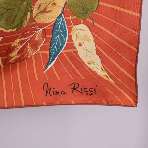 Närbild på hörn med Nina Ricci logga på scarfen