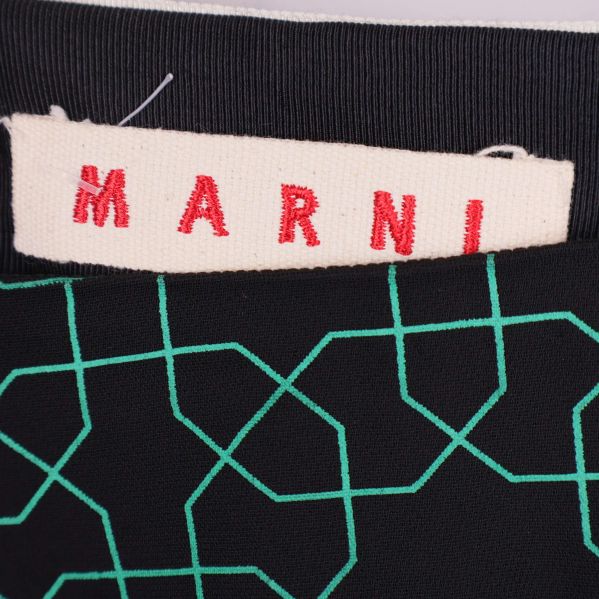 Närbild på Marni-logotyp på tygmärke i kjolen