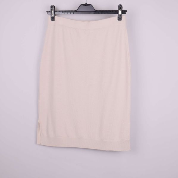 Beige stickad kjol sedd bakifrån på galge