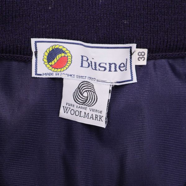 Närbild på Busnel-etikett och Woolmark-märke med storlek 38