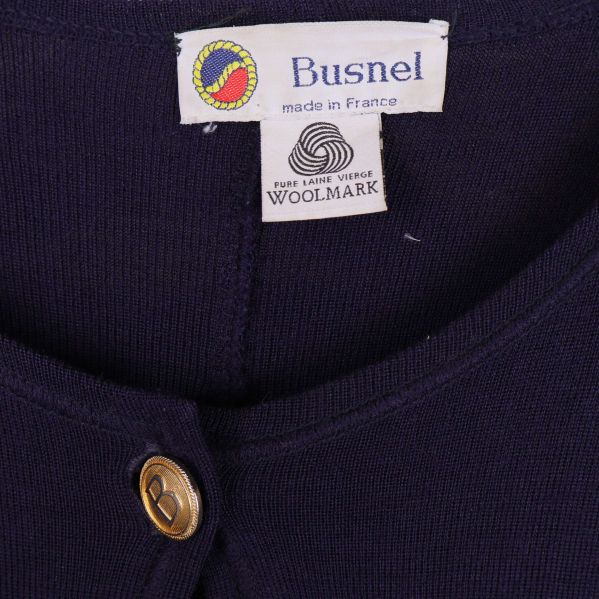Nära etikett från Busnel och Woolmark på mörkblå ullcape