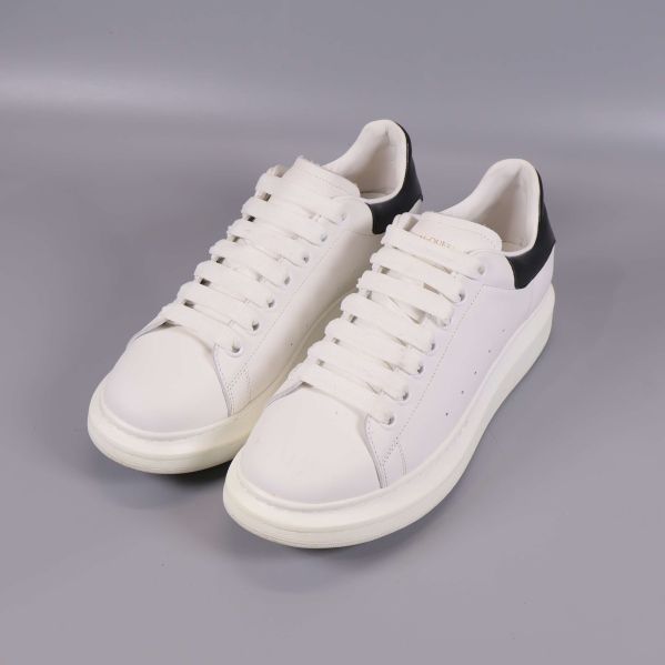 Sneakers i vitt med svart häl i vinklad vy