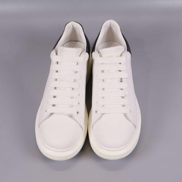 Sneakers framifrån med vit ovandel och snörning