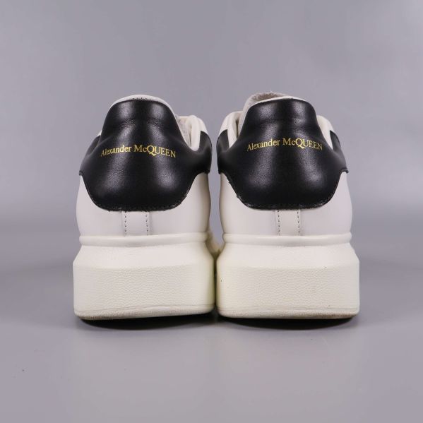 Baksida av sneakers med svart häl och guldtext