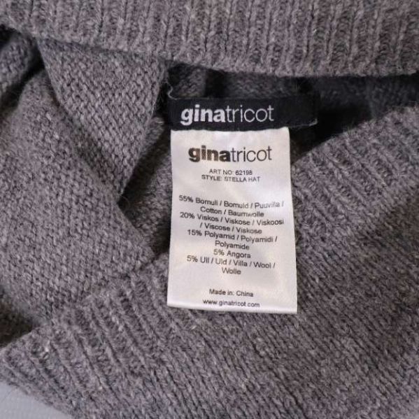 Material- och varumärkesetikett från Gina Tricot inuti mössan