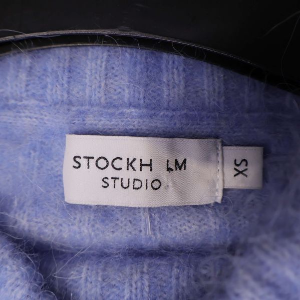 Närbild på etikett stockh lm studio i tröjan