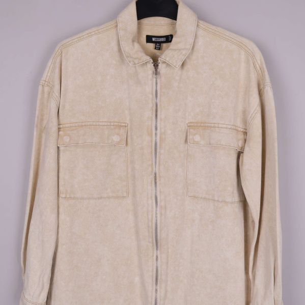 Beige skjortjacka med dragkedja och bröstfickor i närbild