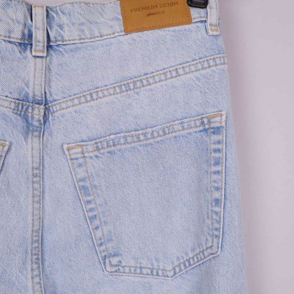 Närbild på bakficka och tygpatch på ljusblå jeans